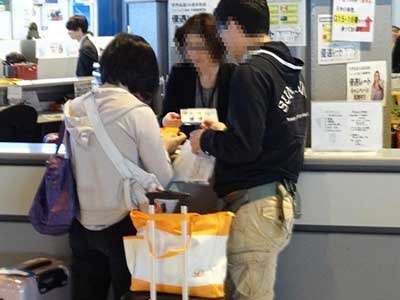 空港チェックインカウンターでの年層男性に向けた男性用化粧品試供品セットのサンプリング事例1
