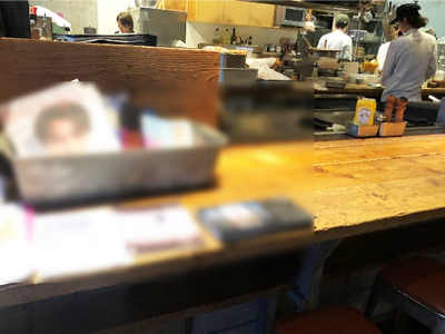 若者や訪日外国人に向けたカフェ/レストランにおける写真展の割引クーポン付きポストカードの設置サンプリング事例