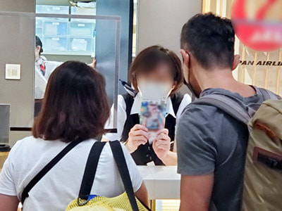 空港旅行代理店カウンターで沖縄渡航客に向けた沖縄で使える旅行系アプリ訴求リーフレットのサンプリング事例3