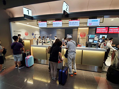 空港旅行代理店カウンターで沖縄渡航客に向けた沖縄で使える旅行系アプリ訴求リーフレットのサンプリング事例2